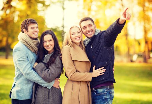 summer, holidays, vacation, happy people concept - group of friends or couples having fun in autumn park