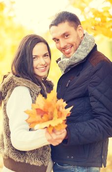 holidays, love, travel, relationship and dating concept - romantic couple in the autumn park