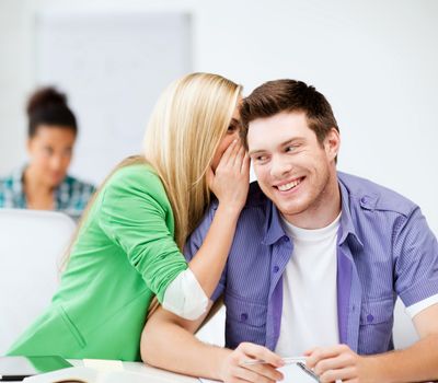 education concept - male and female students talking at school or college