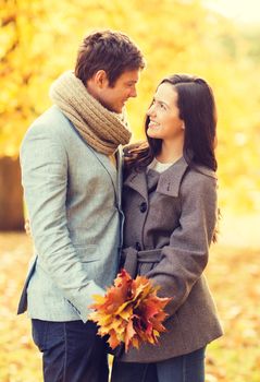 holidays, love, travel, relationship and dating concept - romantic couple kissing in the autumn park
