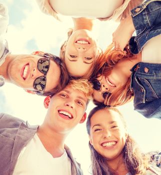 summer holidays and teenage concept - group of teenagers looking down