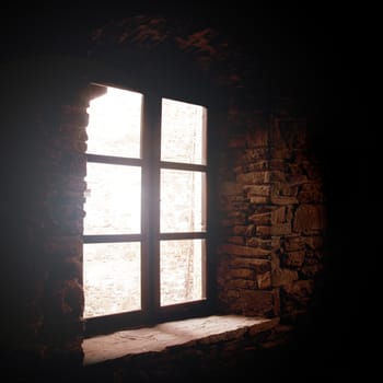 Old medieval window in dark room.