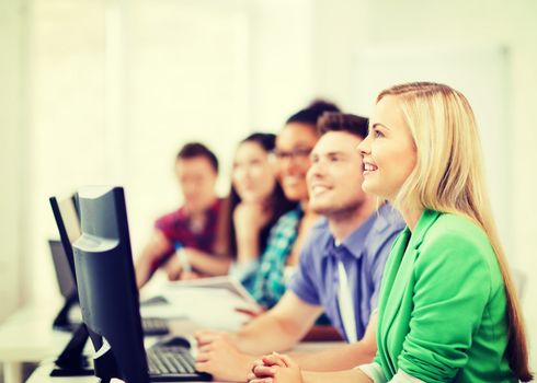 education concept - students with computers studying at school