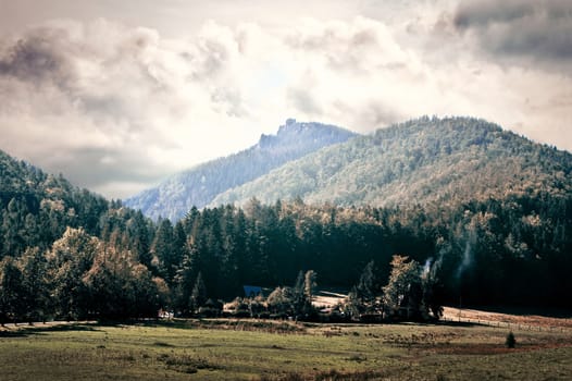 Dark clouds over mountains and field. Nature conceptual image.