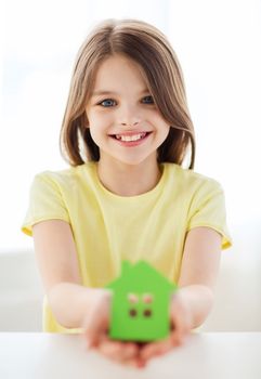 home and family concept - little girl holding green paper house