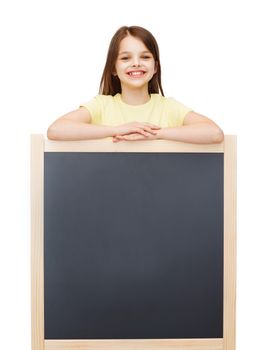 people, advertisement and education concept - happy little girl with blank blackboard