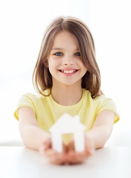 home and family concept - little girl holding white paper house