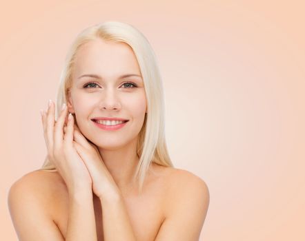 health and beauty concept - face and hands of happy woman