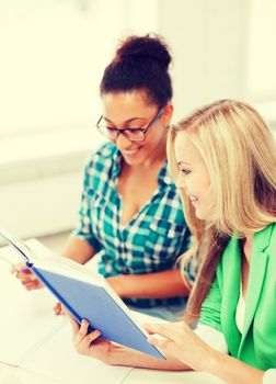 education concept - smiling student girls reading book at school