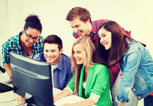 education concept - students with computer studying at school