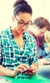 education concept - smiling international student girl with smartphone at school