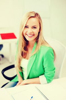 education concept - smiling student girl studying in college