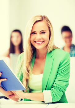 education concept - smiling young girl reading book at school