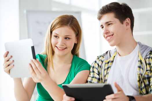 education, technology and internet concept - smiling students with tablet pc computers at school