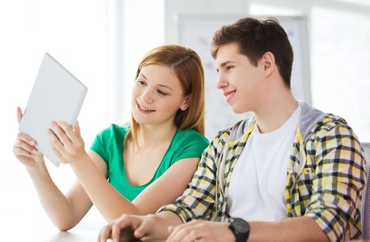 education, technology and internet concept - smiling students with tablet pc computers at school