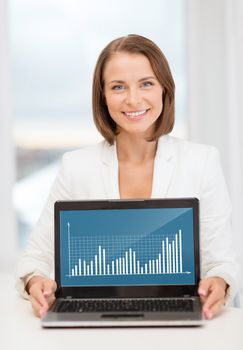 education, business, technology and internet concept - smiling woman with laptop computer in office