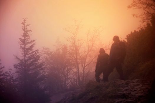 Tourists between fog on the trip in mountains. Abstract blurred picture.