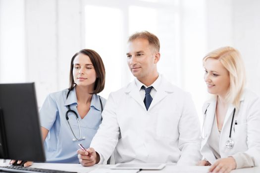 healthcare, medical and technology - group of doctors looking at computer on meeting