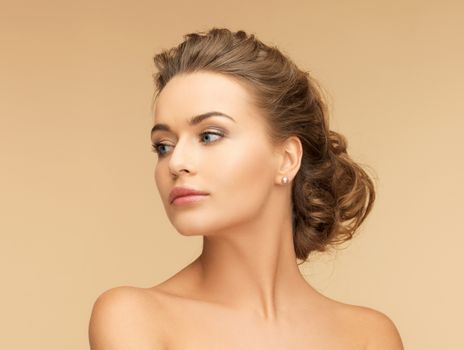 beauty and jewelery concept - beautiful woman with pearl earrings
