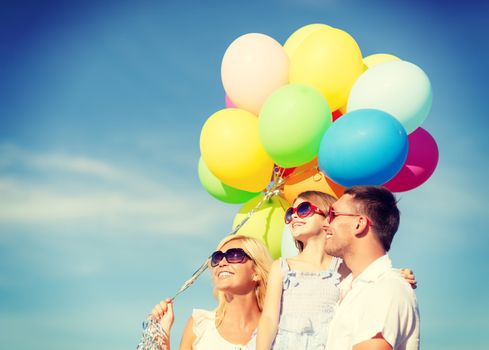 summer holidays, celebration, children and people concept - happy family with colorful balloons outdoors