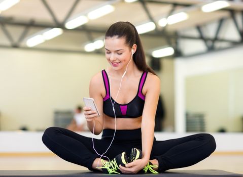 fitness, sport, gym, technology and lifestyle concept - smiling woman with smartphone