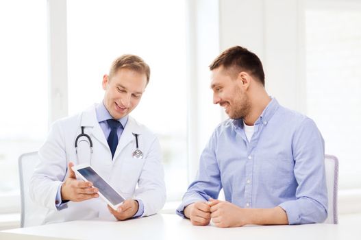 healthcare, technology and medicine concept - smiling doctor with tablet pc computer and patient in hospital