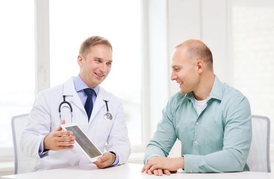 healthcare, technology and medicine concept - smiling doctor with tablet pc computer and patient in hospital