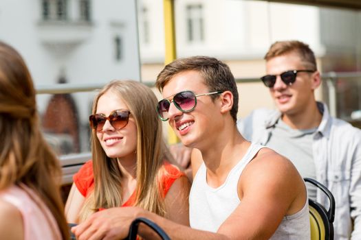 friendship, travel, vacation, summer and people concept - smiling couple traveling by tour bus