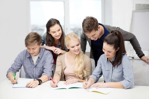 school and education concept - group of smiling students with notebooks at school