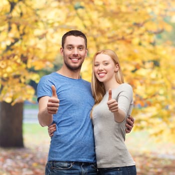 couple, gesture and family concept - smiling couple showing thumbs up