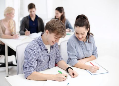 school and education concept - group of smiling students with notebooks at school