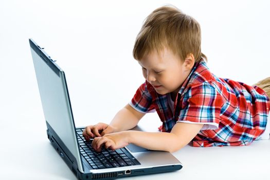Little boy lying on the floor with a laptop