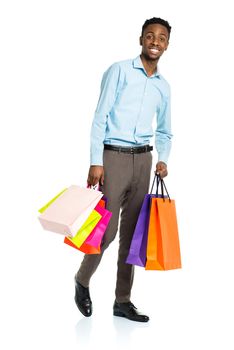 Happy african american man holding shopping bags on white background. Shopping and holidays concept