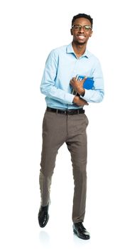 Happy african american college student with books in his hands standing on white background
