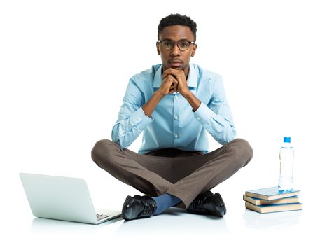 African american college student with laptop, books and bottle of water sitting on white background