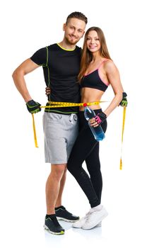 Happy sport couple - man and woman with measuring tape on the white background