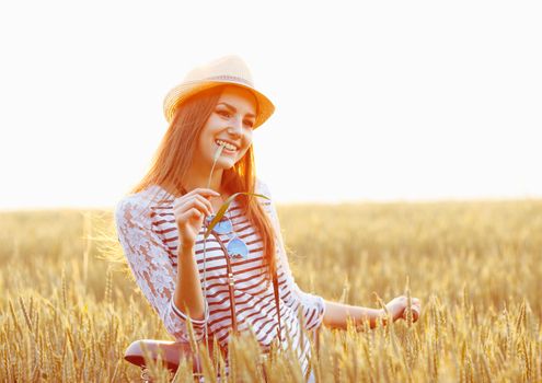 Lovely young woman stands in a field with her bicycle. Lifestyle concept