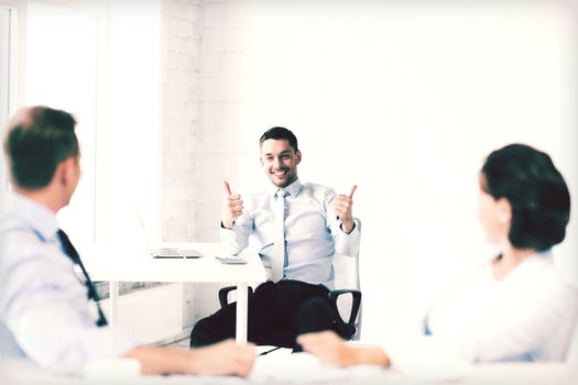 business concept - businessman showing thumbs up in office
