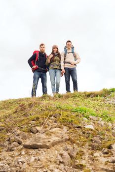 adventure, travel, tourism, hike and people concept - group of smiling friends with backpacks outdoors