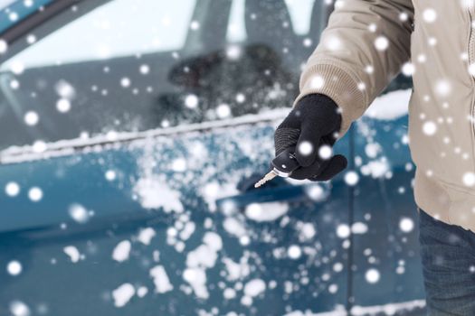 transportation, people, season and ownership concept - close up of man with car key outdoors