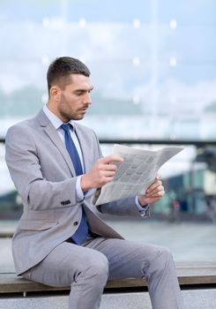 business, hot drinks and people and concept - young serious businessman with newspaper over office building