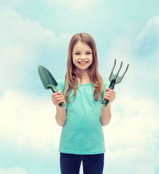 garden and people concept - smiling little girl with rake and scoop