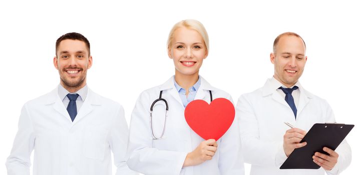 medicine, profession, teamwork and healthcare concept - group of smiling medics or doctors holding red paper heart shape, clipboard and stethoscopes over white background