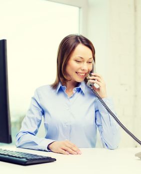 business, communication and education concept - smiling businesswoman with laptop and telephone