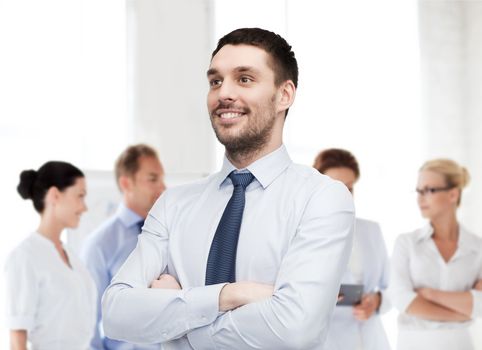 business and office concept - handsome businessman with crossed arms