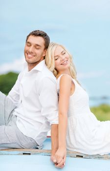 summer holidays and dating concept - smiling couple at sea side