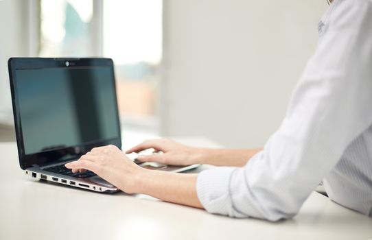 business, technology, communication and people concept - close up of woman typing on laptop computer at office or home