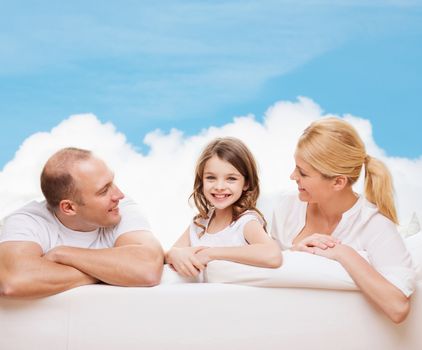 family, childhood and people - smiling mother, father and little girl over blue sky and white cloud background