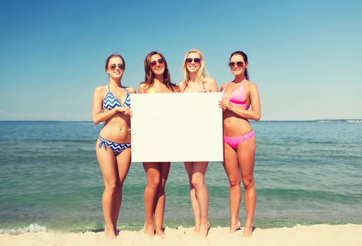 summer vacation, holidays, travel, advertising and people concept - group of smiling young women with big white blank billboard on beach