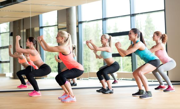 fitness, sport, training, gym and lifestyle concept - group of women working out in gym